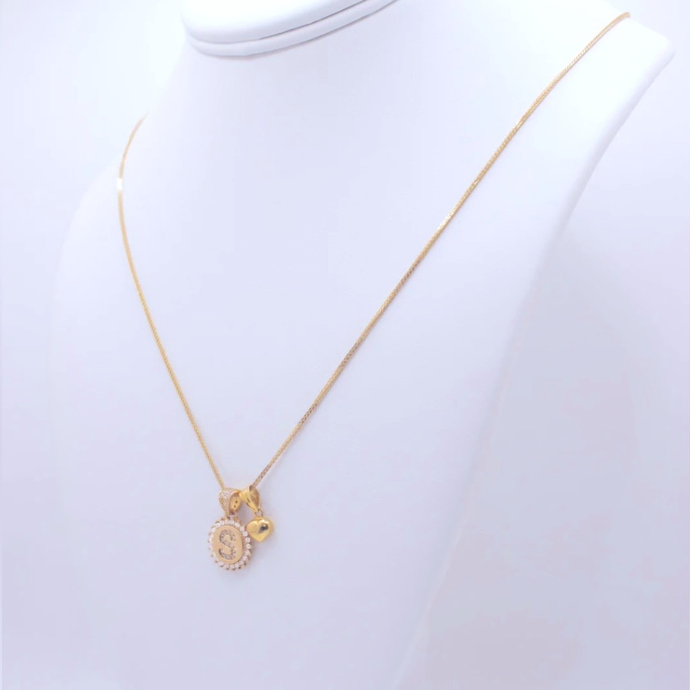 “S” pendant surrounded by white stones with a small heart charm.